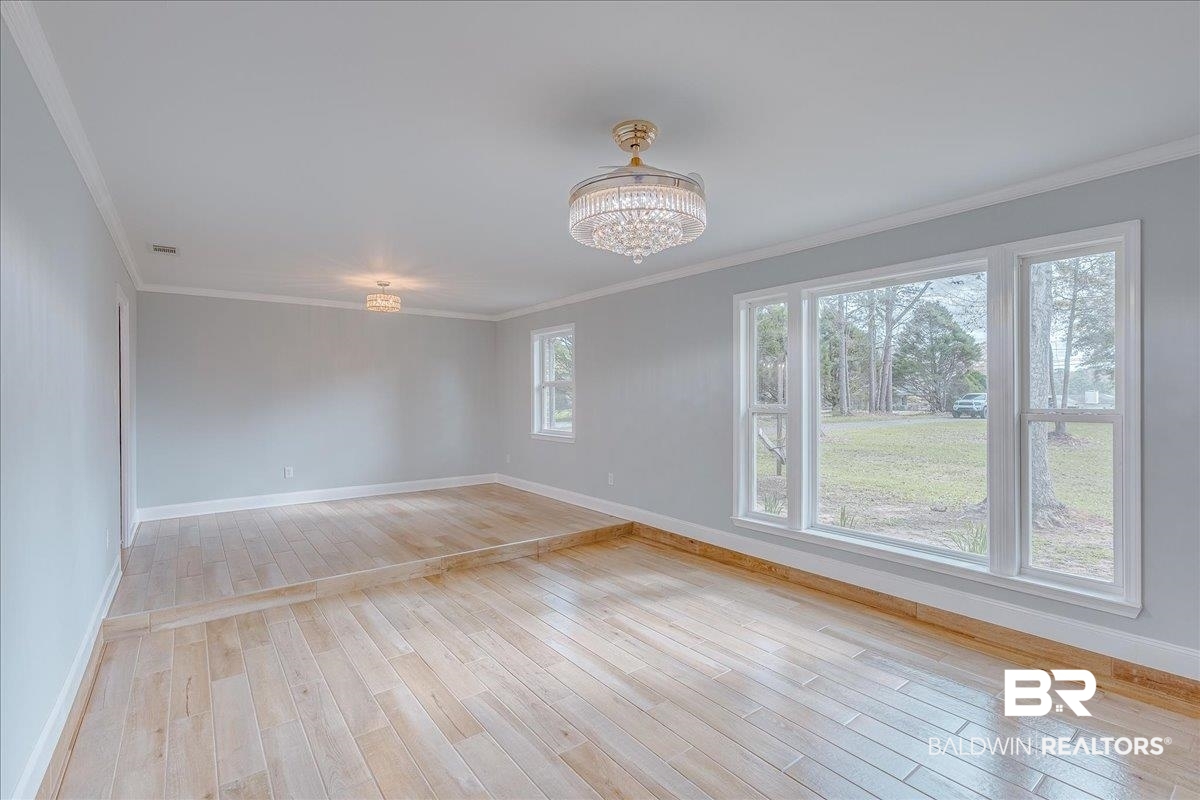 440 Dykes Road Mobile, AL 36608 - Photo 5 of 49 Spare room featuring a notable chandelier, baseboards, light wood-style floors, and ornamental molding