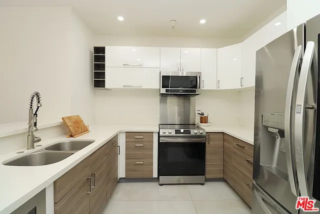 a kitchen with stainless steel appliances a sink stove and refrigerator