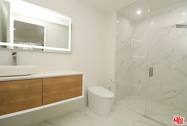 a bathroom with a toilet a sink and mirror