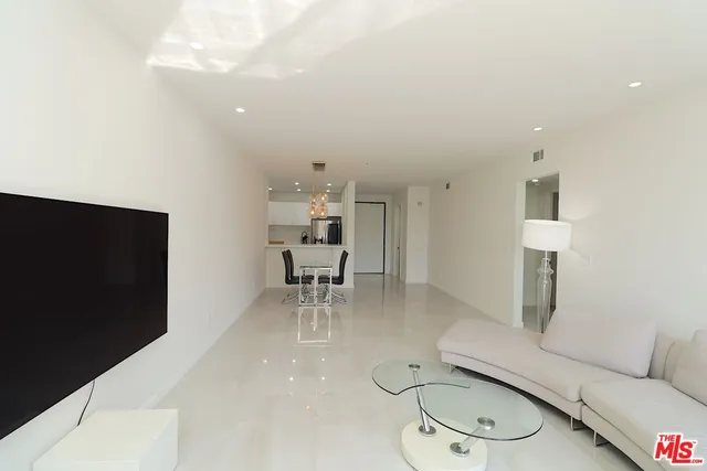 a living room with furniture a dining table and a painting on the wall