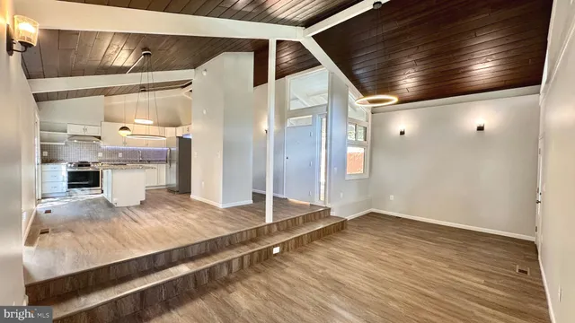 a living room with stainless steel appliances kitchen island granite countertop furniture and a fireplace