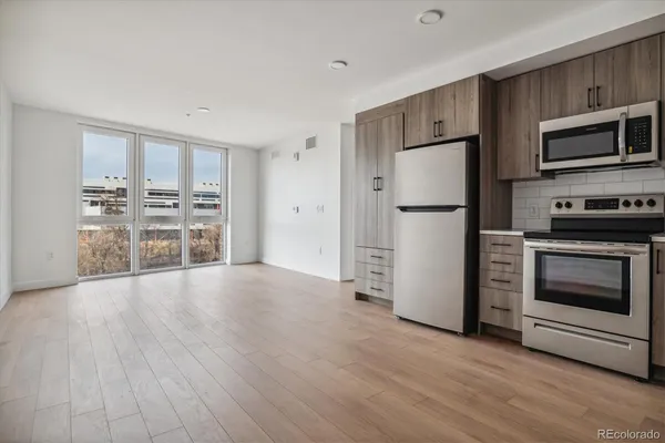 a kitchen with granite countertop a refrigerator and a stove top oven