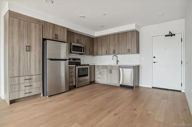 a kitchen with kitchen island a white cabinets and stainless steel appliances