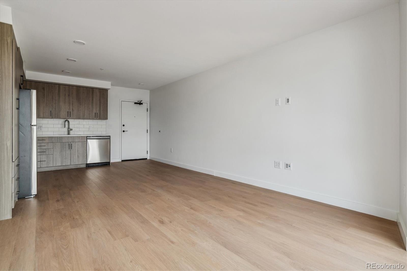 3575 Chestnut Place, Unit 702 Denver, CO 80216 - Photo 4 of 8 a view of a kitchen with a dishwasher and a refrigerator