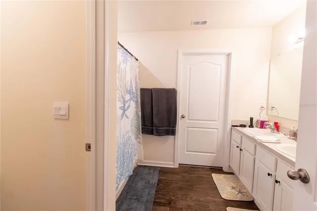 a bedroom with a bed and a lamp on dresser