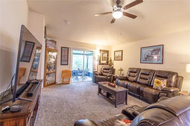 a kitchen with stainless steel appliances granite countertop a table chairs a refrigerator and a stove top oven