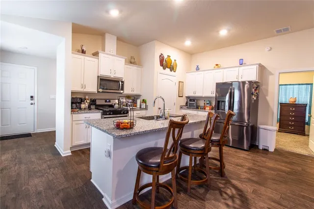 a kitchen with stainless steel appliances granite countertop a sink stove and refrigerator