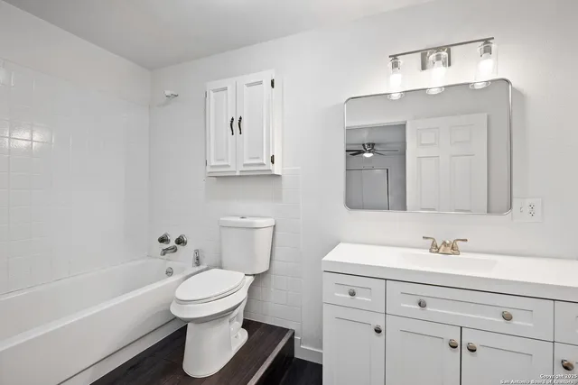 a bathroom with a sink toilet a mirror and bathtub