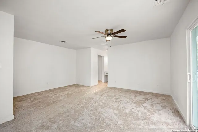 an empty room with a empty space and a ceiling fan