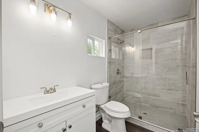 a bathroom with a shower a toilet and a sink