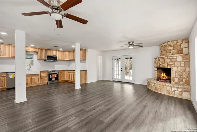 a view of an empty room with a fireplace and window