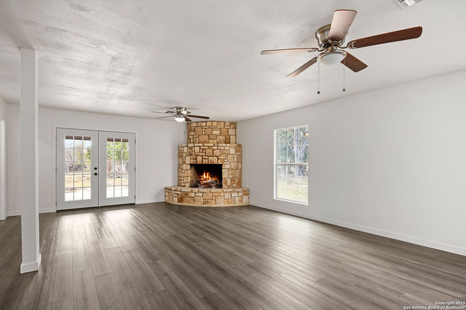 213 Verde Hills Drive Center Point, TX 78010 - Photo 5 of 37 a view of an empty room with wooden floor fireplace and a window
