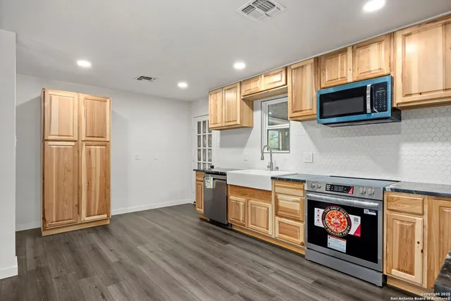a kitchen with stainless steel appliances granite countertop a stove a microwave and a refrigerator