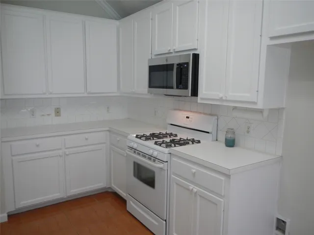 a kitchen with white cabinets and white appliances