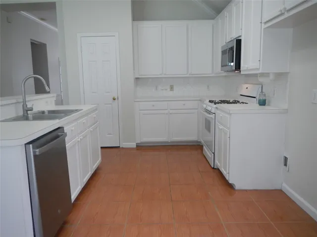 a kitchen with a sink stove and cabinets