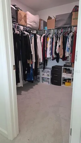 a view of walk in closet with clothes