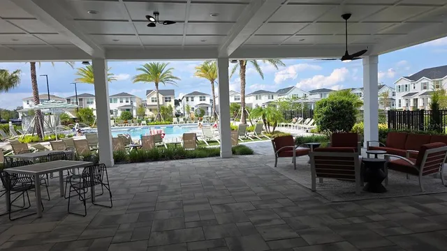 a view of a patio with a table chairs and a floor to ceiling window
