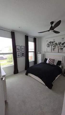 a bedroom with a bed and a large window