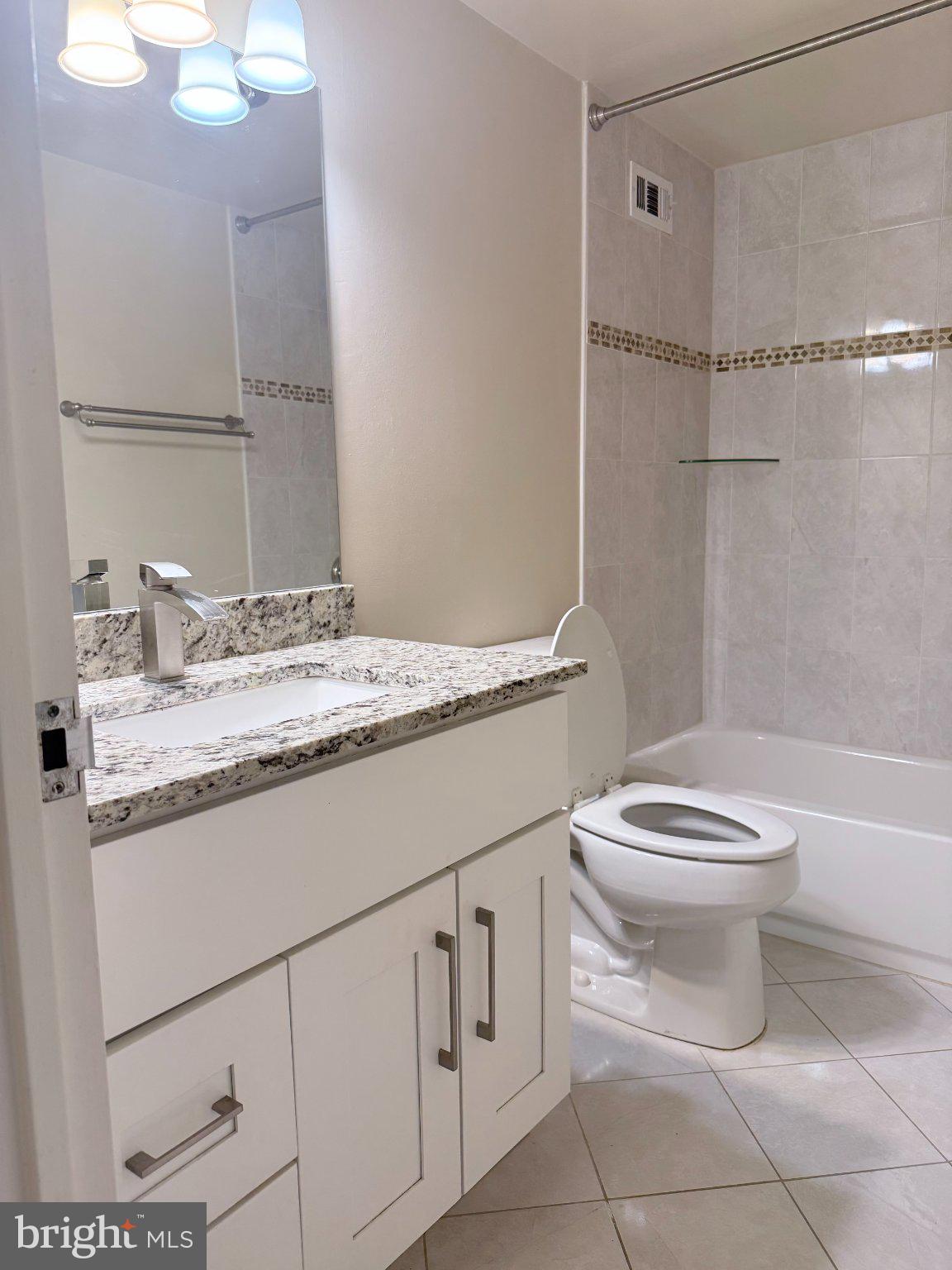 5225 Pooks Hill Road, Unit 1326 Bethesda, MD 20814 - Photo 17 of 24 a bathroom with a granite countertop toilet sink and mirror