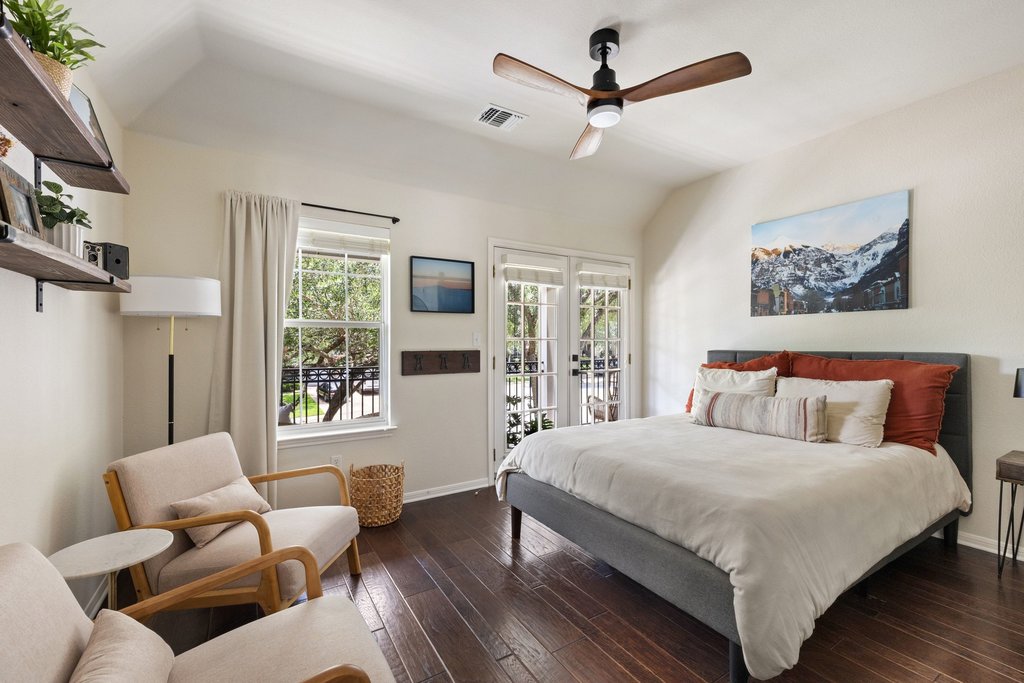 6704 Kiev Cove Austin, TX 78739 - Photo 28 of 37 Hardwood floors and French doors define this inviting primary bedroom, with vaulted ceilings and a refreshing ceiling fan.