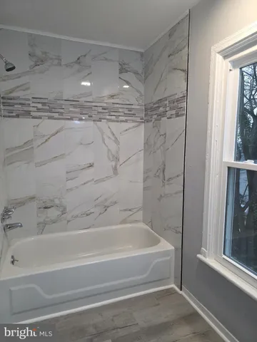 a bathroom with a shower and a bath tub