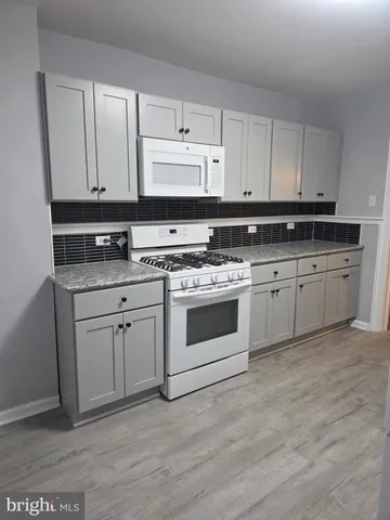 a kitchen with white cabinets and white appliances