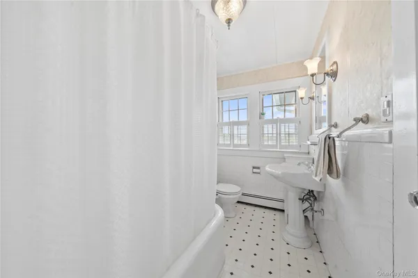 a spacious bedroom with a large bed a flat tv screen and a dresser