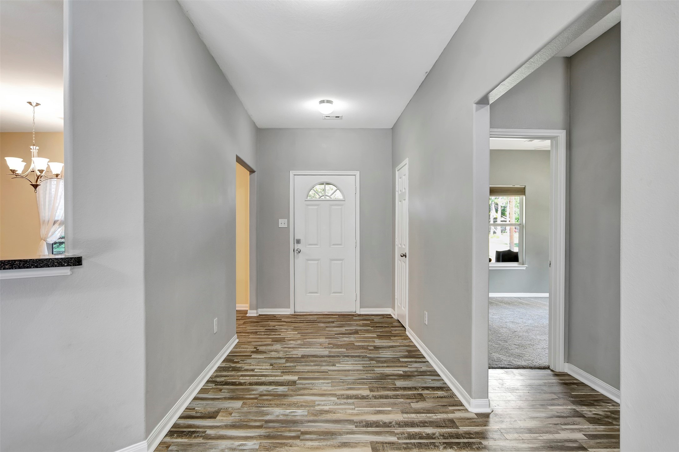 25896 Lake View Court West Hockley, TX 77447 - Photo 6 of 47 a view of a hallway with wooden floor and a bathroom