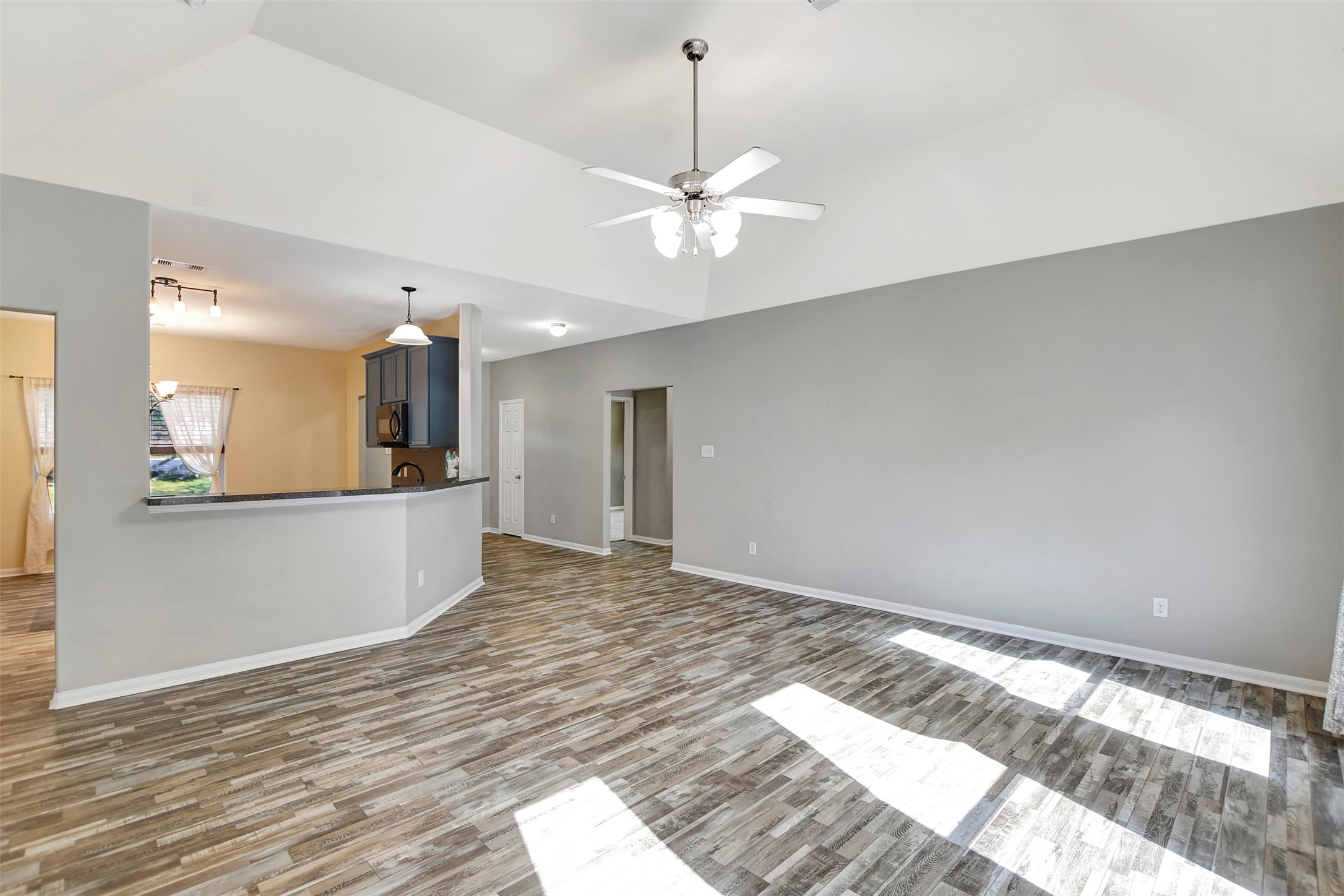 25896 Lake View Court West Hockley, TX 77447 - Photo 10 of 47 a view of a kitchen with wooden floor and a ceiling fan