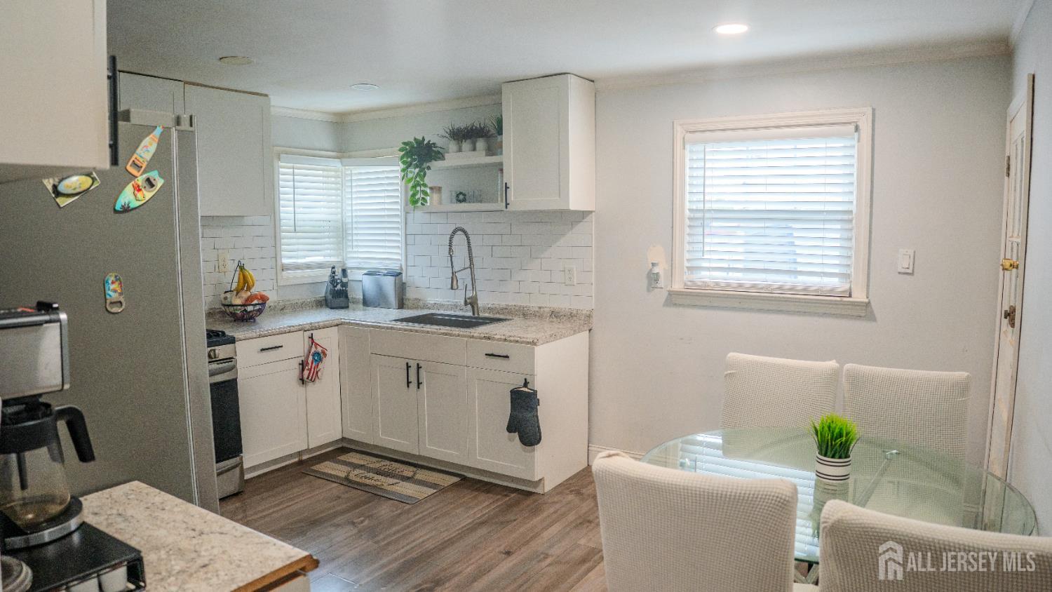 636 Lee Street Perth Amboy, NJ 08861 - Photo 8 of 35 a view of a kitchen with a sink dishwasher and a dining table with wooden floor