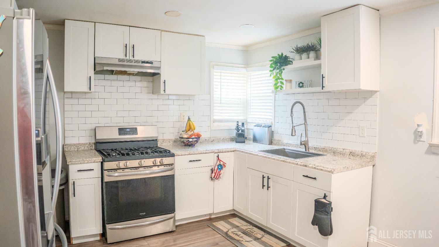 636 Lee Street Perth Amboy, NJ 08861 - Photo 10 of 35 a kitchen with stainless steel appliances a sink stove and cabinets
