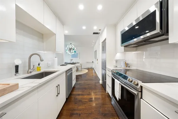 a kitchen with stainless steel appliances a sink stove top oven and cabinets