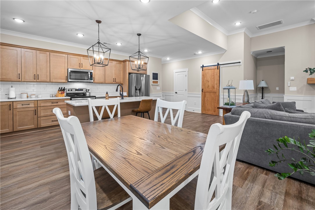322 Thompson Street Pendleton, SC 29670 - Photo 8 of 38 Warm wood tones and warm flooring anchoring an open-concept living and dining layout.