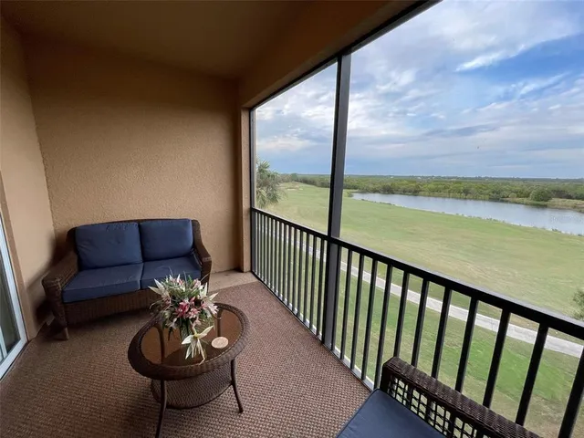 a view of a balcony with chairs and wooden floor