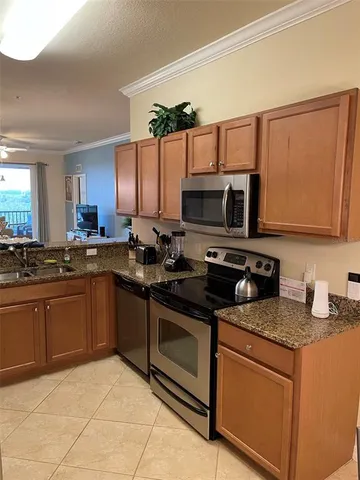 a kitchen with stainless steel appliances granite countertop a stove top oven a sink dishwasher and a microwave oven on the blue kitchen countertops