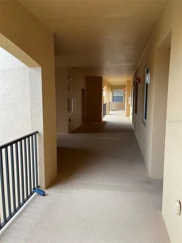 a view of a hallway with wooden floor and windows