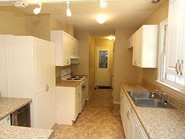 9101 Ray Road Raleigh, NC 27613 - Photo 6 of 14 a kitchen with a stove a sink and a refrigerator