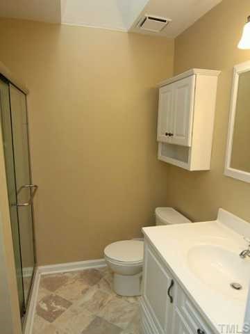 9101 Ray Road Raleigh, NC 27613 - Photo 9 of 14 a bathroom with a sink a toilet and a mirror