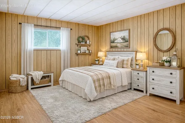 a bedroom with a bed a dresser and next to a window
