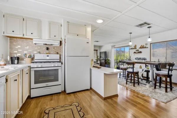 a kitchen with a refrigerator and white cabinets