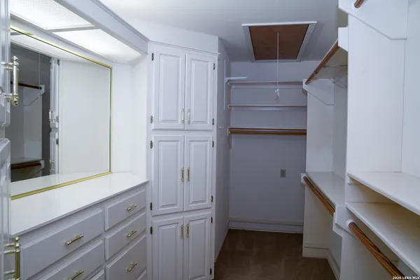 a view of a hallway and closet with wooden floor