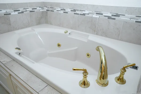 a view of a backyard with large trees and wooden fence