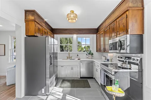 a kitchen with stainless steel appliances granite countertop a sink and a refrigerator