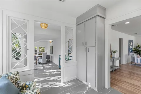 a view of a hallway with wooden floor and a living room