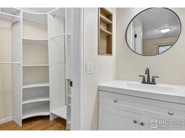 a bathroom with a sink a mirror a vanity and a toilet