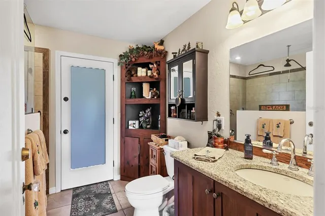 a bathroom with a granite countertop sink toilet and shower