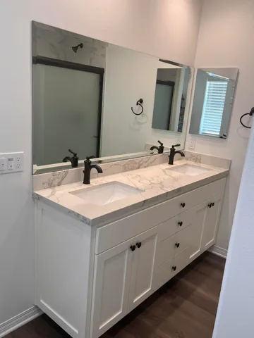 a bathroom with a double vanity sink and a mirror