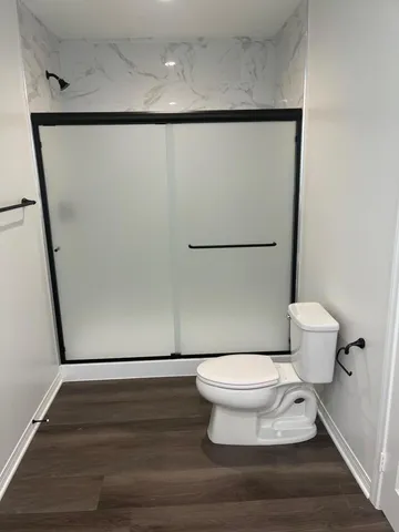 a bathroom with a toilet and a shower