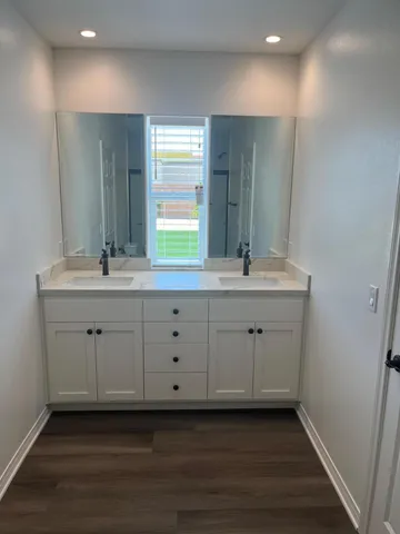 a bathroom with a double vanity sink and a mirror