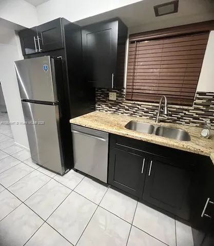 a kitchen with stainless steel appliances granite countertop a refrigerator and a sink